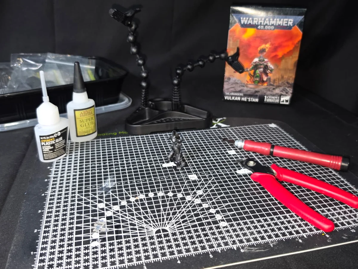 Miniature assembly workspace with hobby tools and components.