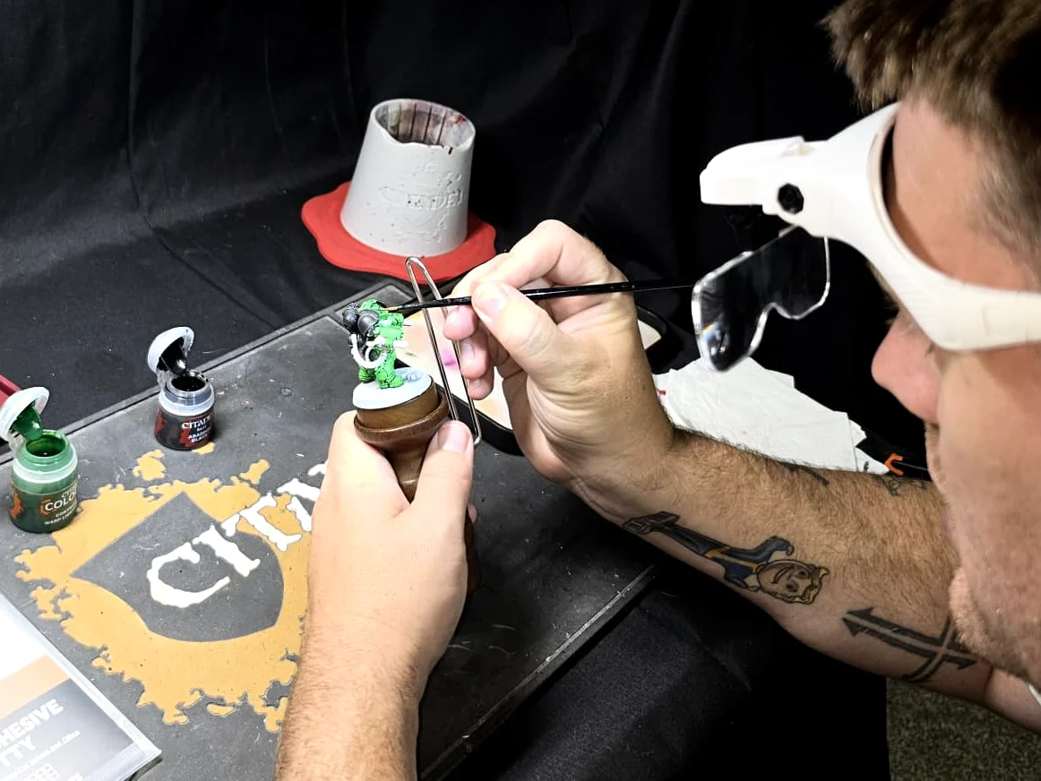Dan painting a miniature at the Forge Without Limits hobby workspace.