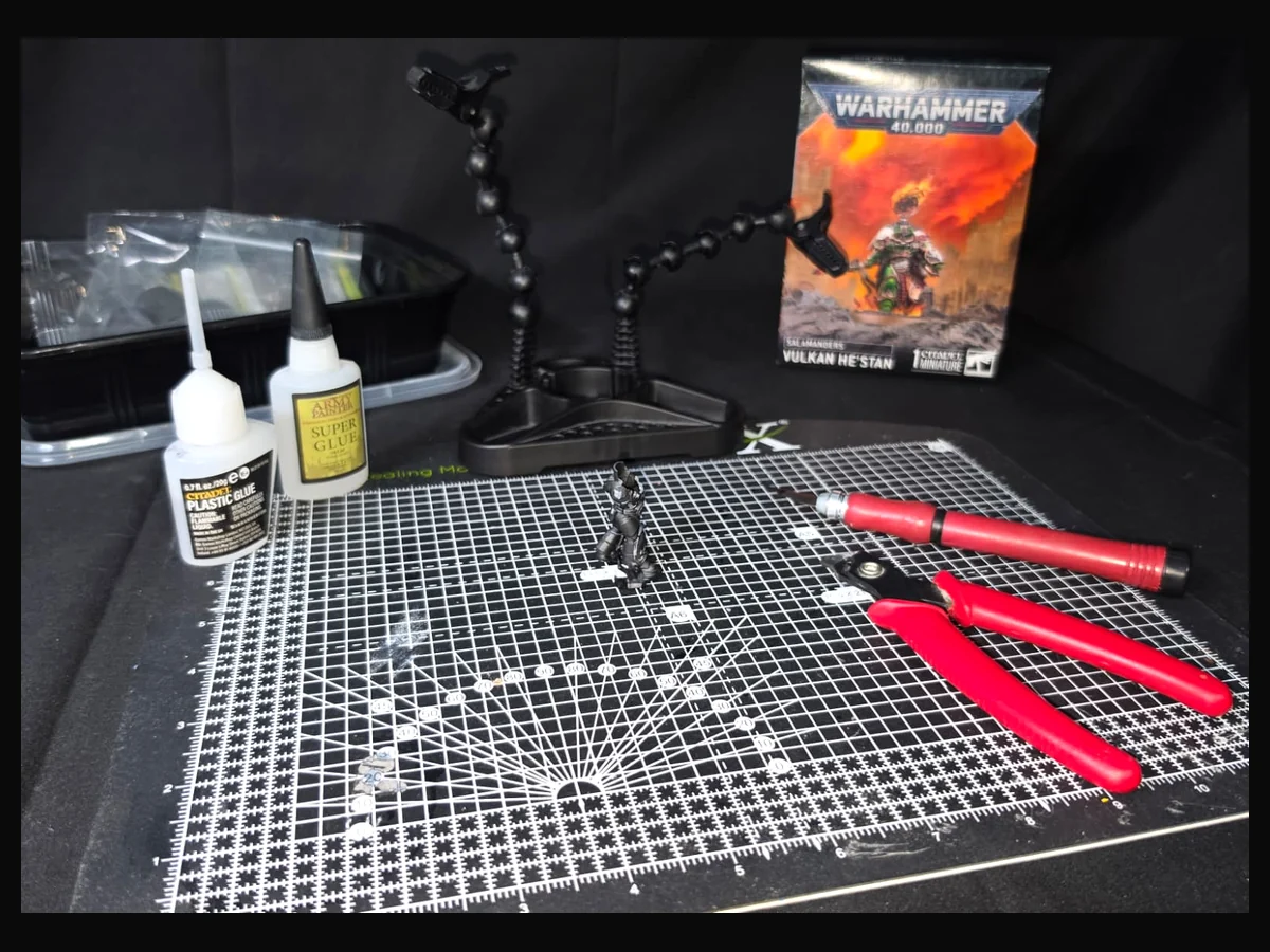 Miniature assembly workspace with tools, glue and model components.