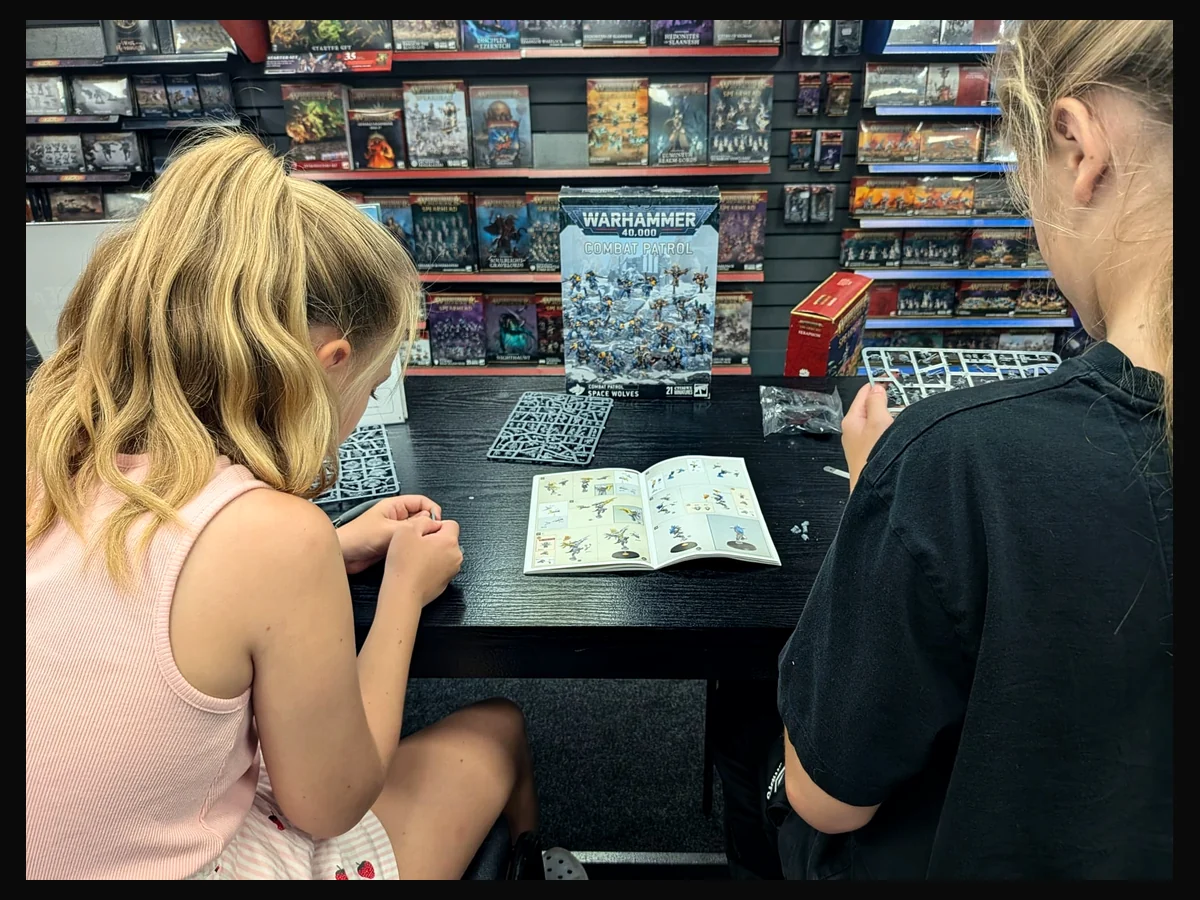 Young hobbyist working on a miniature during a hobby-store visit.