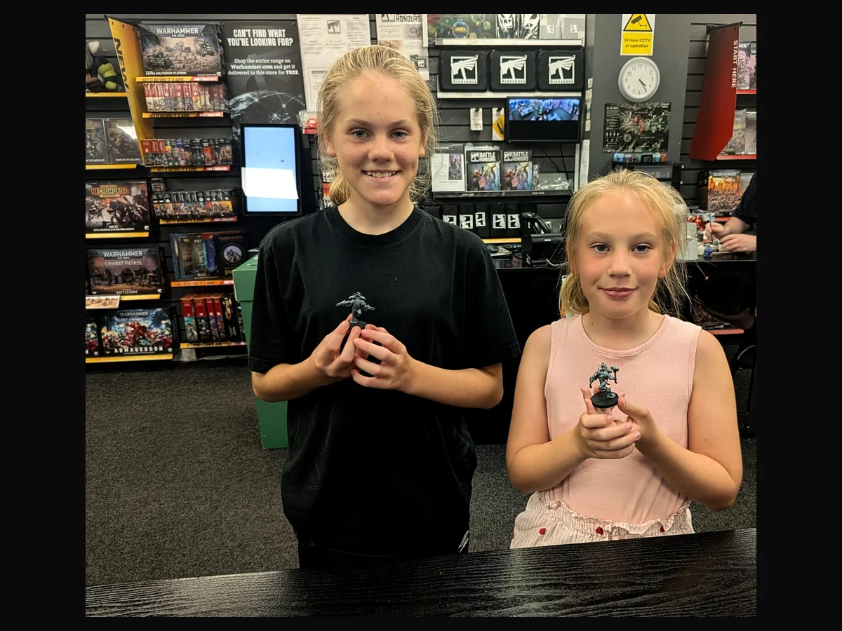 Young hobbyists proudly holding completed miniature models.